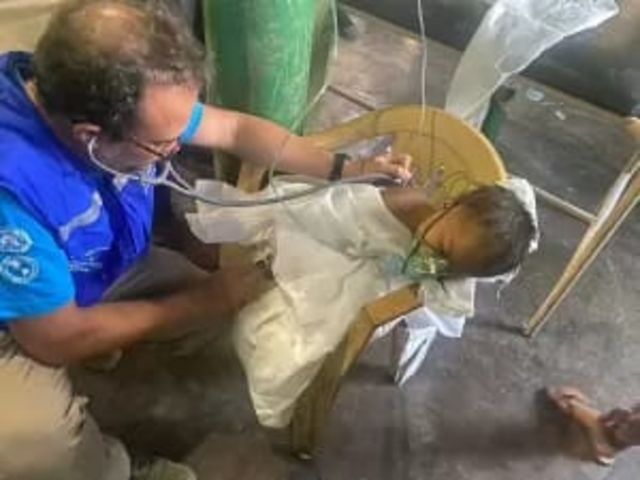 El doctor André Siqueira (a la izquierda) atiende a un niño yanomami.