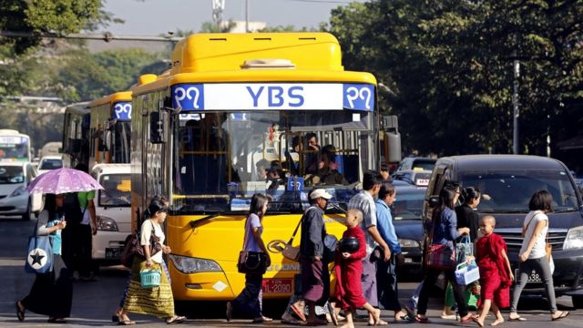 People walk in front of a YBS bus at a traffic light during rush hour in Yangon, Myanmar, 16 January 2017