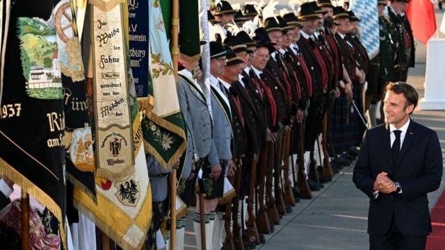On the eve of the G7 summit, French President Emmanuel Macron (right) arrives at the airport in Munich, Germany, to review a guard of honor made up of traditional Bavarian rifles.
