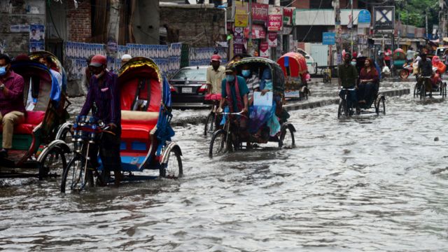 Vehicles attempt to navigate the streets following a heavy downpour in Dhaka, Bangladesh.