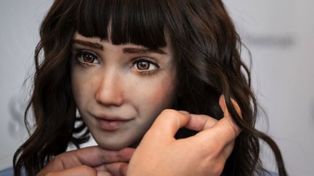 A staff sets the wig of healthcare assistant robot "Grace"