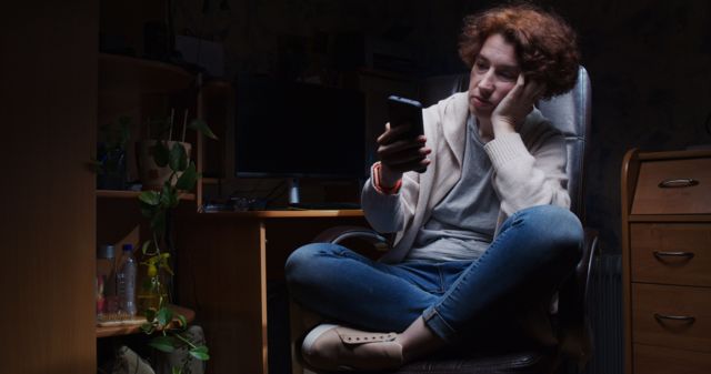 Una mujer triste mirando los mensajes en su teléfono