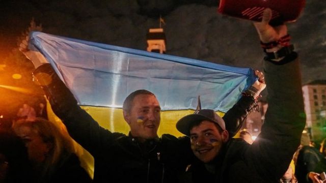 Warga Ukraina merayakan di Maidan Square yang terkena dampak pemadaman listrik.