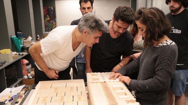 Alejandro Aravena works on an architecture project with others.