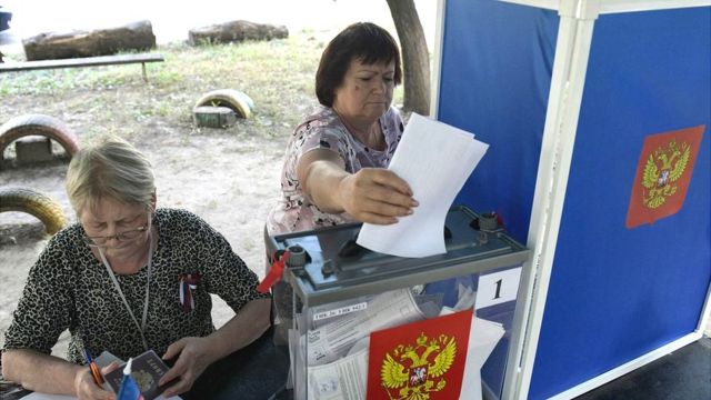 A woman casts her ballot at a mobile polling station in Donetsk