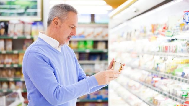 Un hombre revisa la etiqueta de un producto en el supermercado.