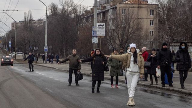 Kiev'de siviller kentten kaçmak için yoldaki arabaların durmasını bekliyor