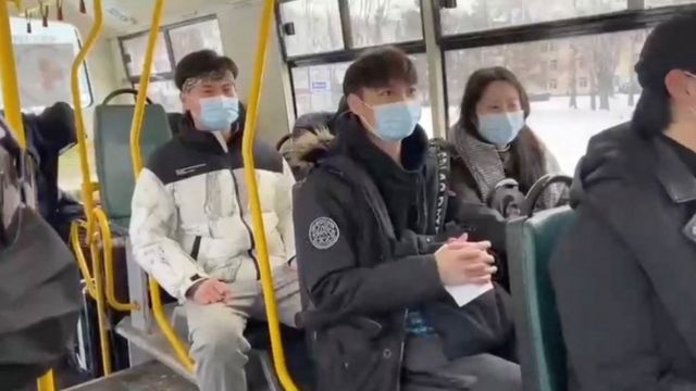Estudantes asiáticos usam máscaras sentados em uma ônibus