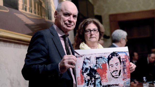يحمل كل من كلاوديو ريجيني (يسار) وباولا ريجيني (يمين) رسم يظهر ابنهما جوليو ريجيني، في مجلس الشيوخ الإيطالي في 3 أبريل/نيسان 2017 في روما