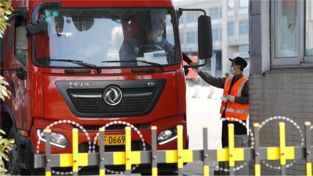 SHANGHAI, CHINA - NOVEMBER 10: A staff member measures the body temperature of a truck driver at Shanghai Pudong International Airport after a new confirmed case of COVID-19 was reported on November 10, 2020 in Shanghai, China. (Photo by Yin Liqin/China News Service via Getty Images)