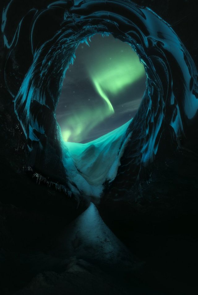 A view over glaciers with the Northern Lights in the sky