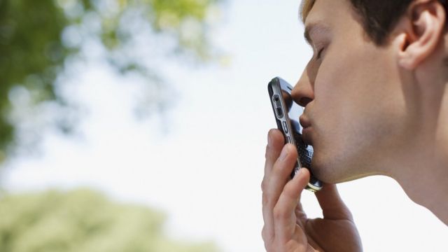 Hombre besa un celular.