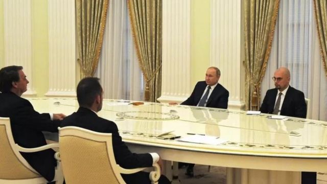 Bolsonaro e Putin sentados em mesa durante encontro