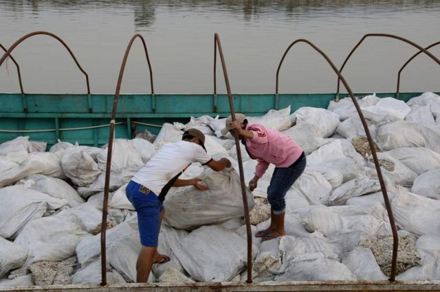 在清盛港，老挝的船只把橡胶从泰国运到中国。