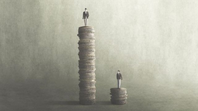 Imagem ilustrando desigualdade, com duas pilhas de moedas, uma grande e uma pequena