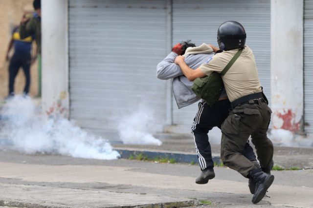 Un agente detiene bruscamente a un manifestante en Quito, Ecuador.