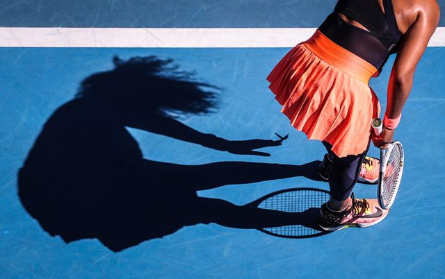 Japan’s Naomi Osaka removes a butterfly from her dress as she plays against Tunisia’s Ons Jabeur during the women’s singles match on day five of the Australian Open tennis tournament in Melbourne on 12 February 2021.