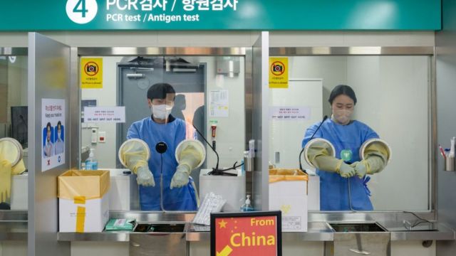 2023/01/02: Quarantine officials seen preparing for a PCR test for travelers arriving from China in COVID-19 testing station at Incheon International Airport, west of Seoul