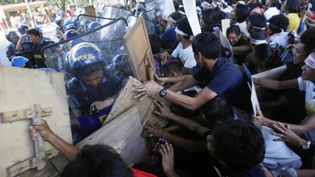 警官隊と押し合うデモ参加者（19日、マニラ）