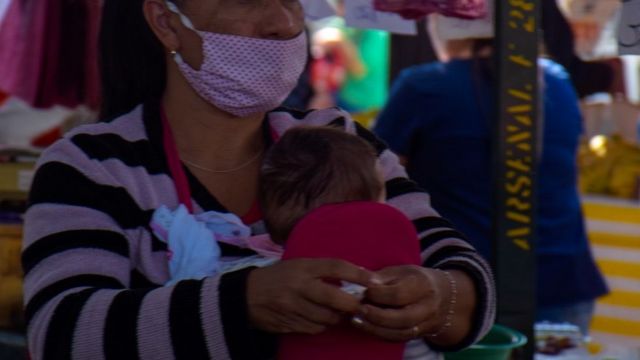 Mulher com criança em feira de SP