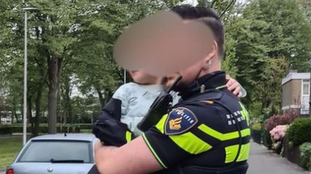رجل شرطة يحمل الطفل