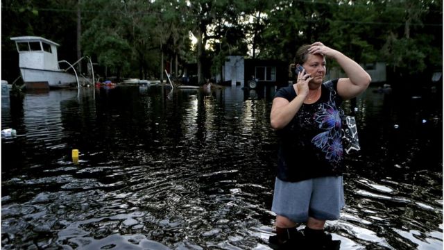Lynne Garrett habla por teléfono con el agua a la altura de la rodilla tras el paso del huracán Hermine por Tampa, Florida, el 2 de septiembre.