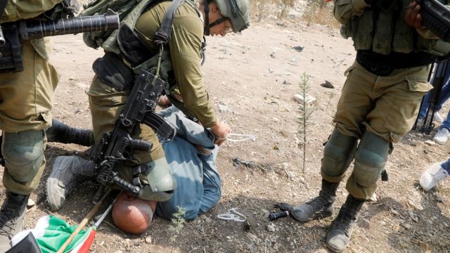 جندي إسرائيلي يجثو بركبته على رقبة ورأس حانون