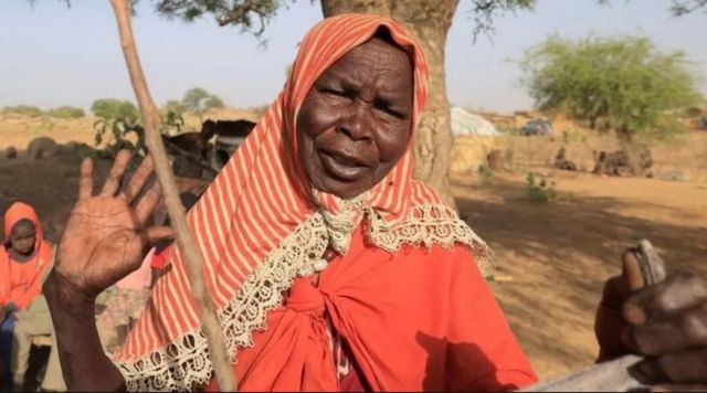 ديفة آدم يوسف، لاجئة سودانية فرت من العنف في إقليم دارفور بالسودان، تتفاعل وهي تقف في مأواها المؤقت تحت شجرة، بالقرب من الحدود بين السودان وتشاد في كفرون، تشاد، 9 مايو/ أيار 2022