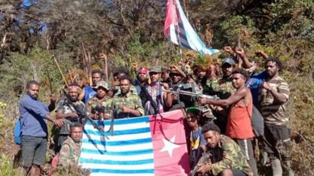 Anggota Tentara Pembebasan Nasional Organisasi Papua Merdeka memegang bendera Bintang Kejora.