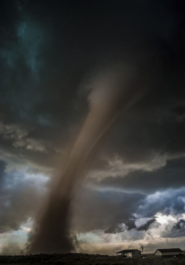 A tornado comes dangerously close to two houses