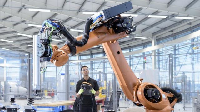 Un empleado observa un brazo robótico