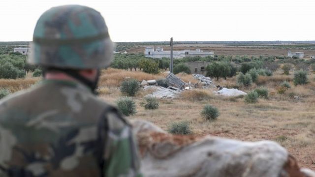 جندي من الجيش السوري يقف في حراسة بينما تتخذ القوات الموالية للحكومة مواقع على خط المواجهة مع المقاتلين المدعومين من تركيا. قرب مدينة منبج في 2 تشرين الثاني / نوفمبر 2019.