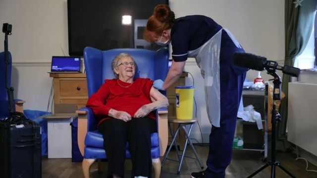 A nurse vaccinating an elderly patient