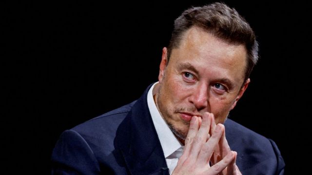 Elon Musk, um homem branco, de terno