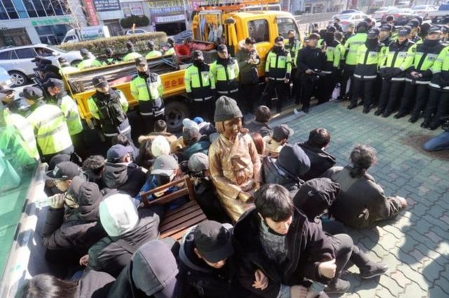 Gente alrededor de la estatua de una "mujer de confort" colocada frente a la embajada de Japón en Busán, Corea del Sur.