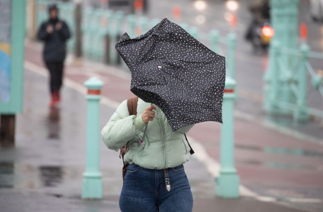 A woman walking along Brighton seafront struggles with her umbrella in the wind as Storm Francis sweeps across the South East of England.
