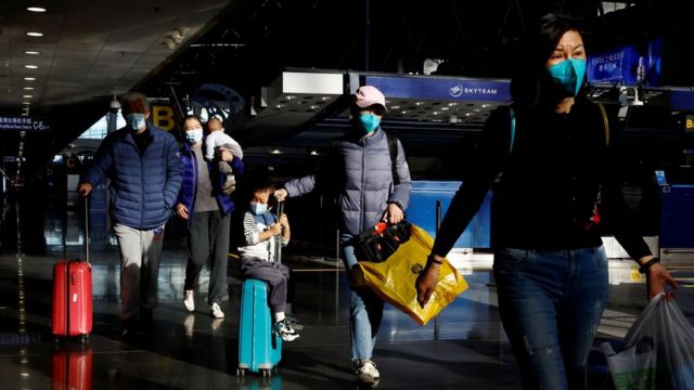 Viajantes caminhando pelo aeroporto internacional de Pequim na terça-feira, 27/12