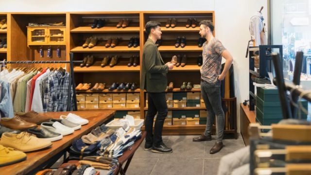 Dos hombres conversan dentro de una tienda de ropa en Corea del Sur.