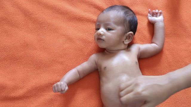 Un bebé recibe masaje en el vientre