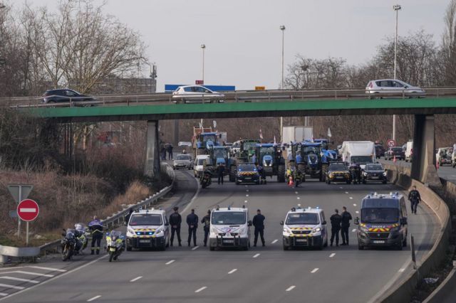 Cordón policial ante los granjeros en una autopista que conduce a París