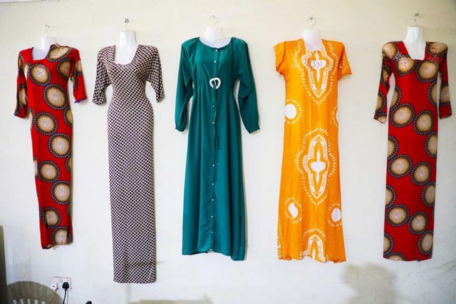 Dresses sewn by former militants training as tailors hang on a wall