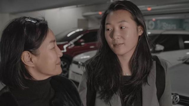 Duas mulheres amarelas conversam em um estacionamento