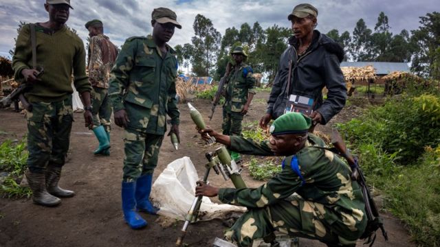 Un militaire de la RD Congo entrain de monter une roquette sous les yeux de ses camarades