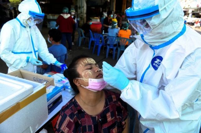 A medical worker performs a nasal swab on a migrant worker at a seafood market amid the coronavirus disease (COVID-19) outbreak in Thailand's Samut Sakhon province on December 19, 2020