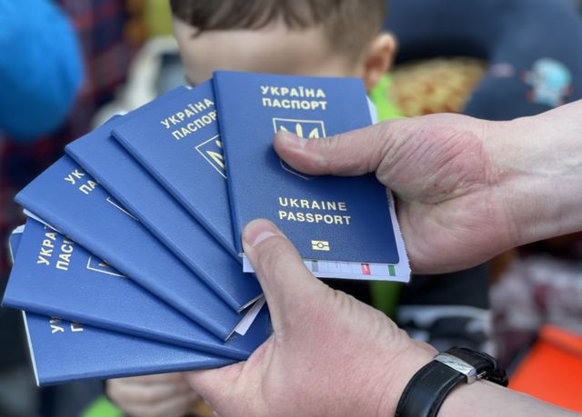 Un hombre muestra los pasaportes ucranianos de su familia en el cruce fronterizo de San Ysidro el 25 de marzo de 2022.