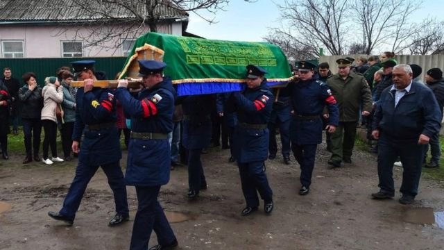 Guardas de honra carregam caixão em funeral de um soldado do Exército russo