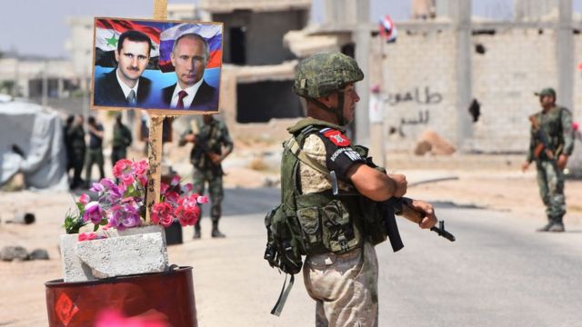 İdlib'in doğusundaki Ebu Duhur geçişine Esad ve Putin posterleri asılı.