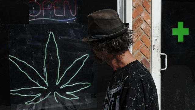 Hombre pasando frente a tienda de marihuana medicinal