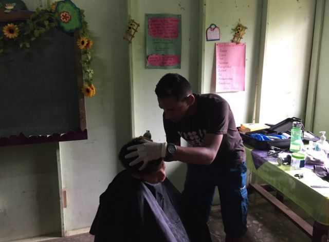 Voluntario de Conexión cortando el pelo a un habitante de 28 Millas, en Limón, Costa Rica. (Foto: Tamara Gil/BBC Mundo)