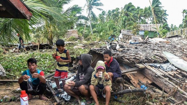 Residentes se alimentan frente a su casa destruida, en la provincia oriental de Samar, 17 de diciembre de 2021